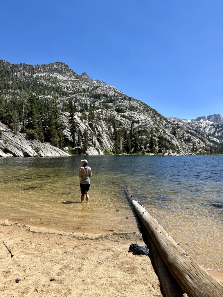 Female Hiker standing in Barney Lake in the Hoover Wilderness along the Benson Lake Loop